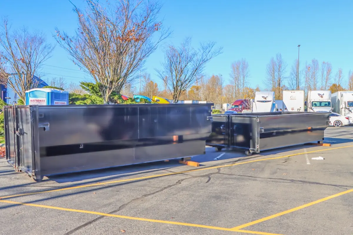 Professional dumpster rental service with roll-off container on residential driveway in DeKalb